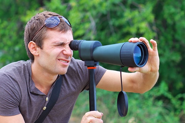 A person using a spotting scope to find owls